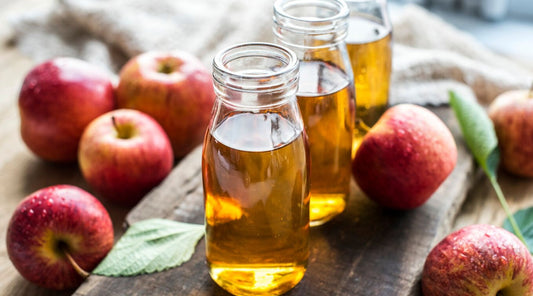 image of an apple cider vinegar surrounded by apples 